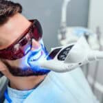 Patient receives dental veneer using light cure.