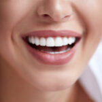 Healthy white smile close up. Beauty woman with perfect smile, lips and teeth. Beautiful Model Girl with perfect skin.